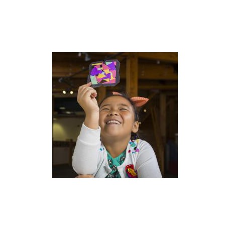 Child holding a tissue paper "stained glass" to the light. Credit NISE Network